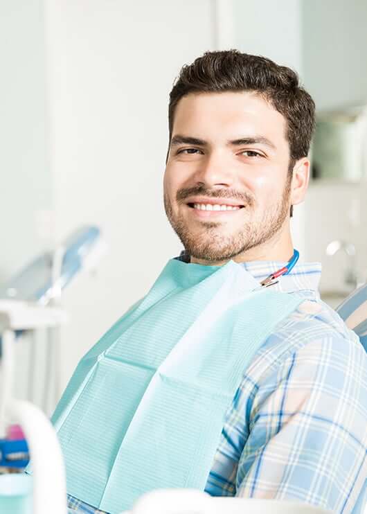 smiling man sitting in a dental chair